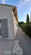 Entrée extérieure d’une maison neuve à Ventabren avec porte bois et éclairage mural